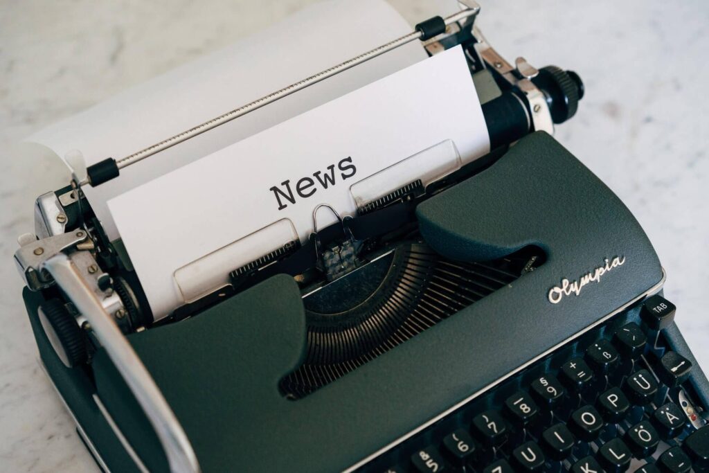 a typewriter with a paper that says "news"